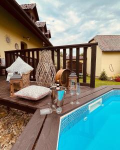 a wooden deck with a table next to a swimming pool at Bohdanečská chalupa in Bohdaneč
