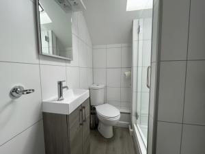 a white bathroom with a toilet and a sink at Barf Cottage in Portinscale +19 photos