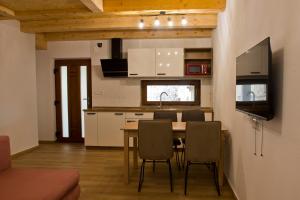 uma cozinha com uma mesa e cadeiras e uma televisão em Apartmaji Tanto Malovše em Črniče