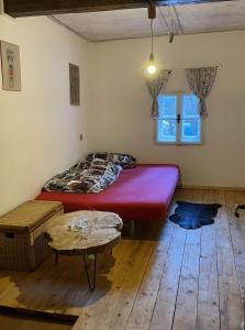 a bedroom with a large red bed and a table at Roubenka Prašivá in Vyšní Lhoty