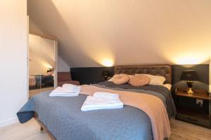 een slaapkamer met een blauw bed en handdoeken bij Apartament Liściasty 2 z widokiem na góry - Dream Apart in Ustroń