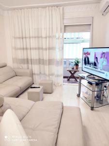 DUPLEX FUENGIROLA CENTRO 3 dormitorios في فوينخيرولا: غرفة معيشة بها أريكة بيضاء وتلفزيون