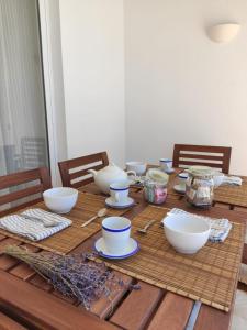 a wooden table with bowls and dishes on it at Villa Coral in Cala'n Porter