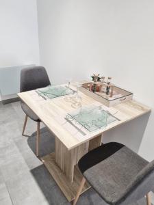 uma mesa de jantar com 2 cadeiras e uma mesa de madeira em Logement chaleureux 2 personnes em Saint-Gaudens