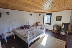 a bedroom with a white bed and a wooden ceiling at Room for guests in Smolyan