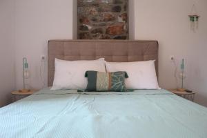 ein Bett mit zwei Kissen darüber in der Unterkunft Melita Traditional Stone House in Pyrgos Dirou