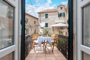 a table and chairs on the balcony of a building at Kotor Nest in Kotor