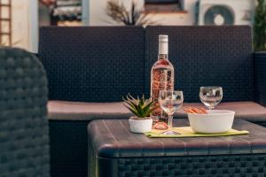 eine Flasche Wein und zwei Gläser auf einem Tisch in der Unterkunft Maison Familiale avec Piscine Privée, plage à pied, Frais Obligatoires à régler à l'arrivée, Linge 15e par pers & Ménage 70e par séjour voir profil Mandatory fees in cash to be paid on arrival linen 15e per person 70e housekeeping per stay in Sainte-Maxime
