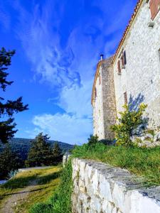 an old building on a hill with a stone wall at Apartman Kolona in Tkon