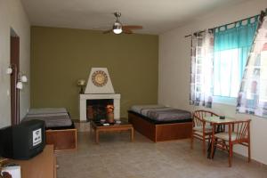 a living room with two beds and a fireplace at KIKI Stegna in Archangelos