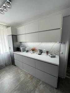 Luxury Apartment في سيبيو: مطبخ بدولاب بيضاء وقمة كونتر