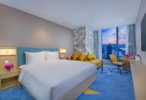 a hotel room with a large bed and a desk at Holiday Inn Express Zhengzhou Longzi Lake by IHG in Yaoqiao +30 photos