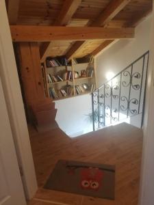 a hallway with a staircase with a book shelf at Apartman Kolona in Tkon
