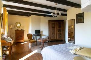 a bedroom with a bed and a table and chairs at Le Clos d'Albray - Chambres d'hôtes et gite in Comps-la-Grand-Ville