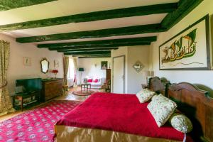 a bedroom with a large red bed with a red rug at Le Clos d'Albray - Chambres d'hôtes et gite in Comps-la-Grand-Ville