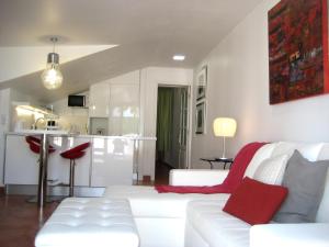 Lacy Golf Apartments في ماسبالوماس: غرفة معيشة مع أريكة بيضاء ومطبخ