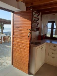 a kitchen with a wooden wall next to a table at Drougas' Windmill in Plaka Milou