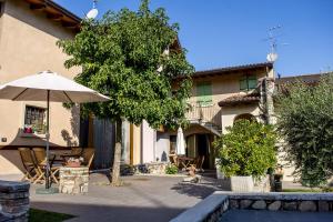 a patio with an umbrella and a building at La Casa del Nonno in Monzambano