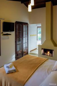 a bedroom with a bed with a fireplace at Pousada Valle dos Pássaros in Penedo