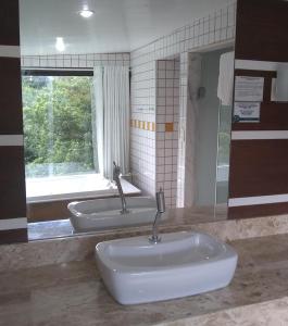 a bathroom with two sinks and a window at Pousada Valle dos Pássaros in Penedo