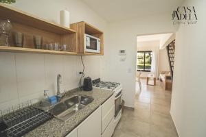 a kitchen with a sink and a stove top oven at Casa Adela - Cabañas Resort in La Rioja