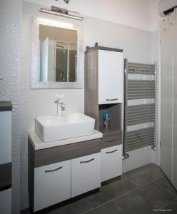 a bathroom with a white sink and a mirror at Apartment "Istra Inspirita" in Rovinj