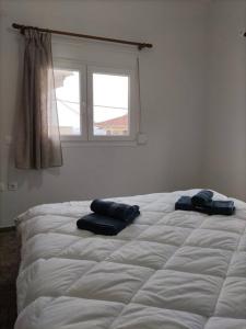 a bed with two pillows on it in a bedroom at Διαμέρισμα κοντά στην θάλασσα in Arkoudi