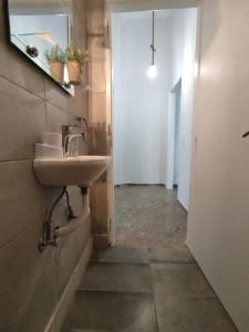 a bathroom with a sink and a mirror and a hallway at Διαμέρισμα κοντά στην θάλασσα in Arkoudi +21 photos