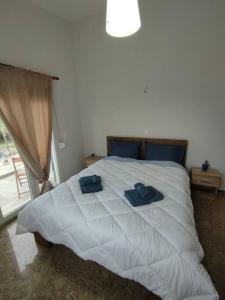a bedroom with a white bed with blue towels on it at Διαμέρισμα κοντά στην θάλασσα in Arkoudi
