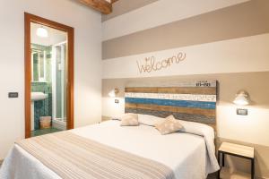 ルッカにあるB&B Stella Luccaのベッドルーム1室(ベッド1台付)、壁にウェルカムサイン