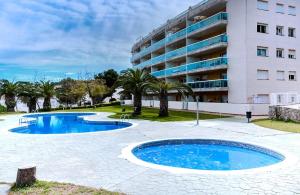 um resort com duas piscinas em frente a um edifício em Apartamento Salou Port Aventura em Salou