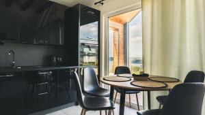 a kitchen with a table and chairs and a large window at Tulichatki domki całoroczne in Tarnawa Dolna