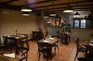 a restaurant with wooden tables and chairs in a room at Hostal Ameztia in Doneztebe