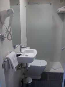 a bathroom with a sink and a toilet and a mirror at Hostal Ameztia in Doneztebe +19 photos