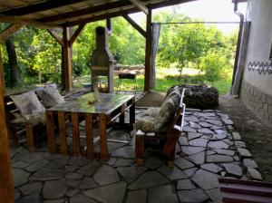 a stone patio with a wooden table and chairs at Hotel Окремий Будинок-Апартаменти in Rakoshyno