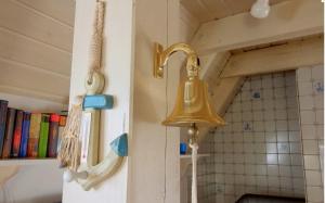 a brass bell on the wall of a bathroom at Dat Onnens Hus - Nordisch mit Herz in Dorum-Neufeld