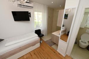 łazienka z toaletą i telewizorem na ścianie w obiekcie Enjoyit Rooms w mieście Velden am Wörthersee