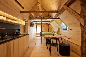 a kitchen and dining room with a table in a cabin at NATUR BAJTA in Solčava