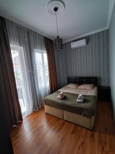 a bedroom with a bed in a room with windows at Kobuleti Guest House in K'obulet'i