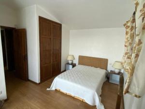 una camera da letto con un letto e una porta di legno di Lovely 6-Bed Cottage in Barcelos - Vila Cova a Barcelos Altre 24 foto
