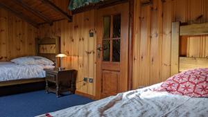 ein Schlafzimmer mit einem Bett und einer Holzwand in der Unterkunft La source in Sondernach