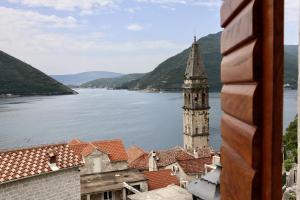 a view of a river and a church with a tower at Monte Bay Retreat Villa in Perast