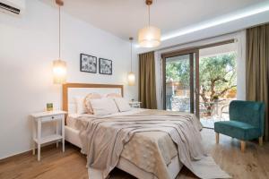 a bedroom with a bed and a chair and a window at Villa Ionio Deste by Villa Plus in Vasilikos