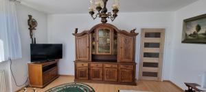 a large wooden cabinet in a living room with a tv at U Tereni na Mazurach in Kuty