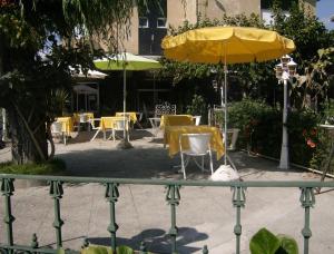 a table and chairs with a yellow umbrella at A Cepa in Santo Tirso