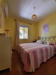 - une chambre avec un grand lit et une couverture violette dans l'établissement Villa de Islantilla, à Islantilla
