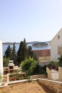 vistas a una casa y a un jardín con agua en Adria Apartment, en Hvar