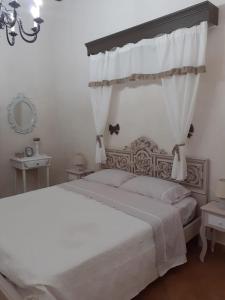 1 dormitorio con 1 cama blanca grande con dosel en Dimora Chloé en Marsala