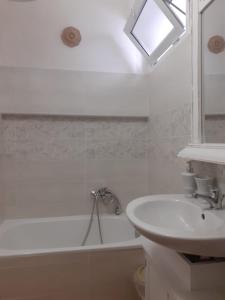 y baño blanco con lavabo y bañera. en Dimora Chloé en Marsala