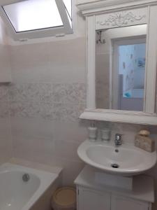 Baño blanco con lavabo y espejo en Dimora Chloé en Marsala
